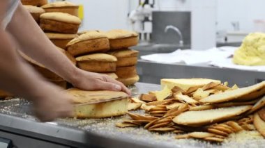 pasta şefi sünger kek katmanları üzerinde kesme. Kek üretim süreci.