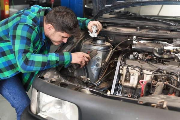 Mecánico guapo hablando por teléfono mientras reparaba un coche  . — Foto de Stock