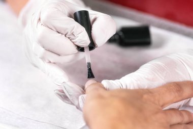 Kadın tırnak tırnak salonu, tırnak cilası uygulayarak bir beutician görüntüsünü kapatmak.