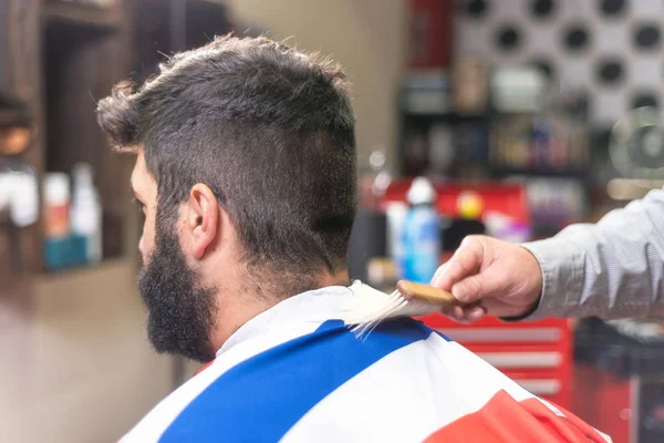 Kapper kapster schoonmaken van de baard met een penseel op een kapper. — Stockfoto