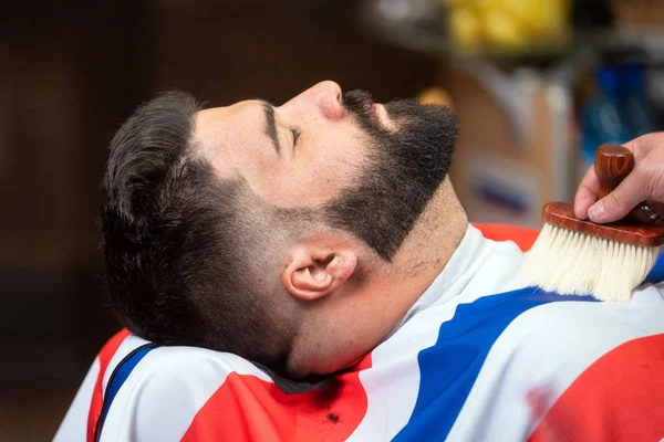 Kapper kapster schoonmaken van de baard met een penseel op een kapper. — Stockfoto