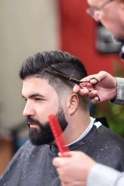 英俊的胡须男子, 在理发店用剪刀剪头发. — 图库照片