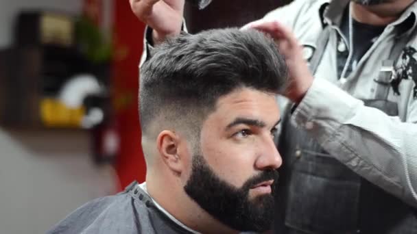 Barbeiro usando cabelo spray fixando penteado na barbearia . — Vídeo de Stock