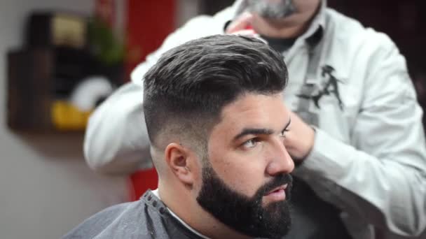 Barbeiro usando cabelo spray fixando penteado na barbearia . — Vídeo de Stock