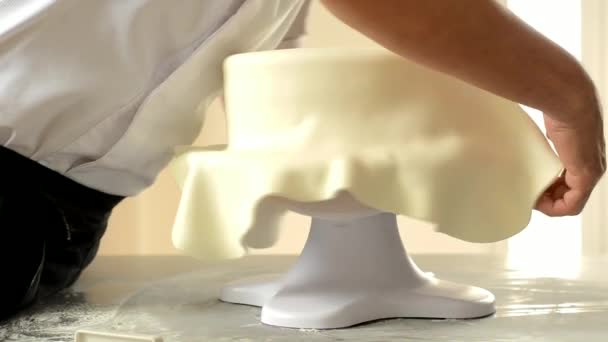 Ομολογητής στολίζει μια γαμήλια τούρτα με λευκό φοντάν. — Αρχείο Βίντεο