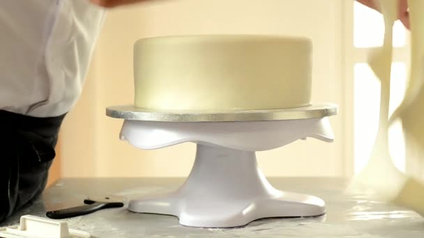Cukrář zdobí svatební dort s bílým fondánem. — Stock video