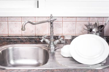 Rustik metal evye üzerinde temiz bulaşıkları kurutma.