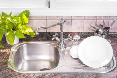 Rustik metal evye üzerinde temiz bulaşıkları kurutma.