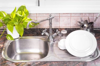 Rustik metal evye üzerinde temiz bulaşıkları kurutma.