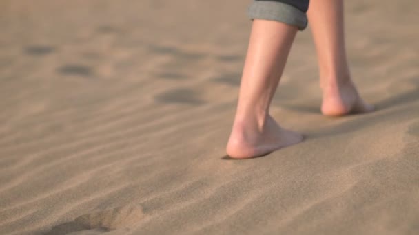 Chiudi, rallentatore. Donna piedi camminando sulla sabbia dorata in spiaggia . — Video Stock