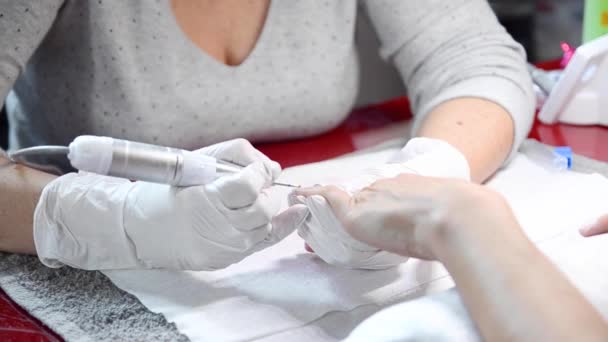 Επαγγελματικό μανικιούρ διαδικασία, καθαρίζοντας τα νύχια με ένα μανικιούρ φρέζα, στο σαλόνι αισθητικός. — Αρχείο Βίντεο