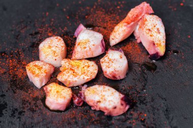 Lezzetli Galiçyaca ahtapot, pulpo a la gallega, üzerinde siyah barut.