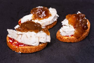 Keçi peyniri ve siyah arduvaz üzerinde karamelize soğan ile tost.