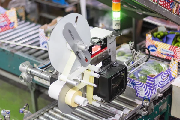 Tenerife, España - 3 de enero de 2019: Máquina de etiquetado automatizada durante la operación en la industria de envasado de alimentos . — Foto de Stock