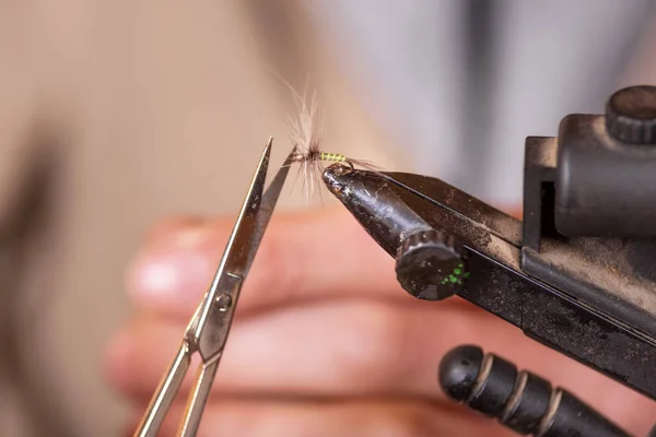 Primo piano del pescatore che lega una mosca per la pesca . — Foto Stock