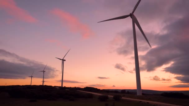 Fazenda de turbina eólica na bela paisagem roxa da montanha do pôr do sol. Produção de energia ecológica renovável . — Vídeo de Stock