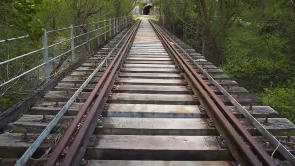 POV strzał chodzenie wzdłuż linii kolejowej. Stary opuszczony jeden utwór na wsi krajobrazu wiejskiego. — Wideo stockowe