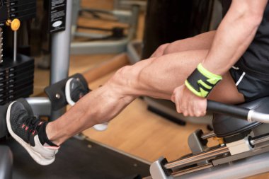 Yakışıklı güçlü adam spor salonunda bacak basın egzersiz yapıldı.