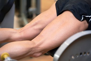 Yakışıklı güçlü adam spor salonunda bacak basın egzersiz yapıldı.