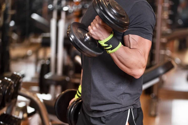 Homme musclé travaillant dans la salle de gym faire des exercices avec haltères au biceps, mâle fort . — Photo