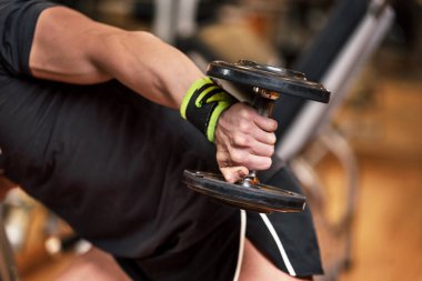 Kas konsepti oluşturmak için ağırlık antrenmanı egzersiz, genç adamın yakın el spor salonunda halter triceps uzatma pozisyonunda egzersiz yapmak.