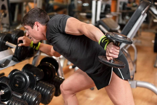 Gewicht training oefening voor het opbouwen van spier concept, close-up hand van jonge man oefenen in halter triceps extensie positie in de sportschool. — Stockfoto