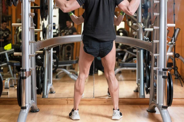 Sport, bodybuilding, lifestyle and people concept - young man with barbell doing squats in gym. — Stock Photo, Image