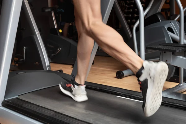 Homme courant dans une salle de gym sur un tapis roulant concept pour l'exercice, fitness et mode de vie sain — Photo