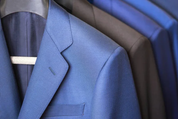 Närbild lyxig stil herrar kostym rad, hängande i en garderob. — Stockfoto