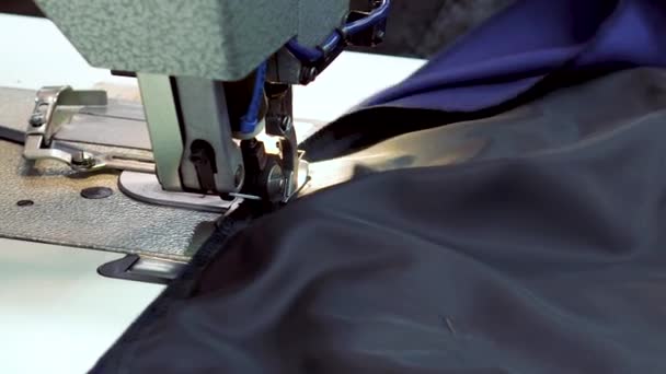 Miejscu pracy krawcowa w fabryce odzieży. Nowoczesne maszyny do szycia w operacji. Do szycia podszewka na kurtkę. — Wideo stockowe