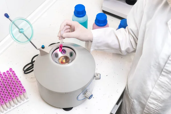 Pesquisador usando equipamentos de laboratório, colocando tubo de amostra na máquina de centrífuga para fazer o teste de laboratório . — Fotografia de Stock