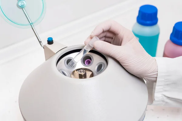 Pesquisador usando equipamentos de laboratório, colocando tubo de amostra na máquina de centrífuga para fazer o teste de laboratório . — Fotografia de Stock