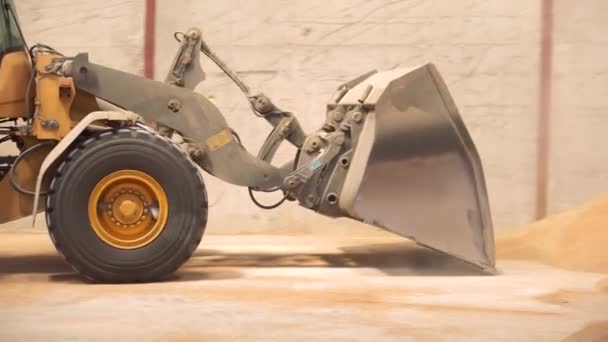 Kolový nakladač pracuje na staveništi. Těžké stroje ve skladu. Kolový buldozer hýbe půdou v kopytech. Zavřít kbelík na bagry. — Stock video
