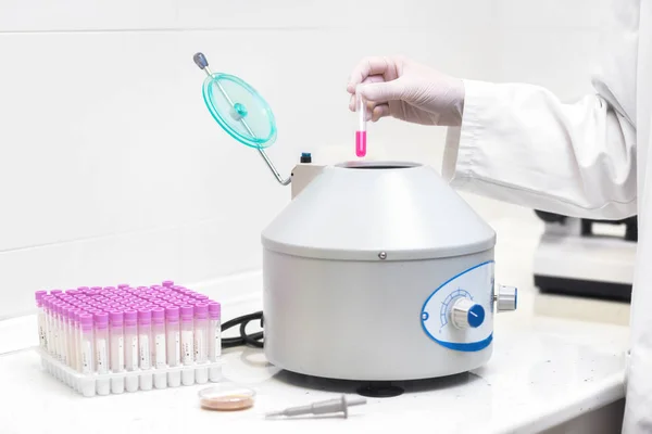 Técnico carregando uma amostra para máquina de centrifugação no laboratório médico ou científico . — Fotografia de Stock