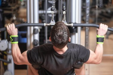 Adam eğitim sırt kasları kolları alarak ve onları aşağı getirerek. Güç egzersiz kavramı.