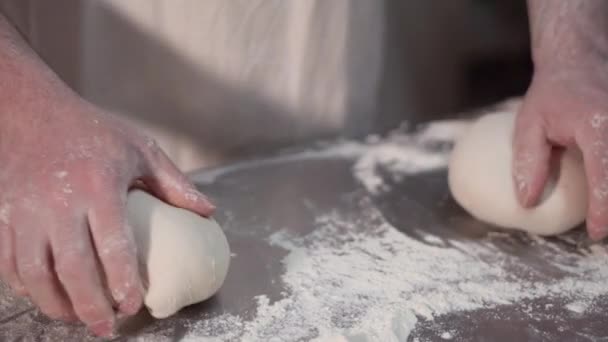 Vista da vicino delle mani del panettiere che impastano l'impasto sul tavolo. Processo di fabbricazione, fare il pane. Rallentatore  . — Video Stock