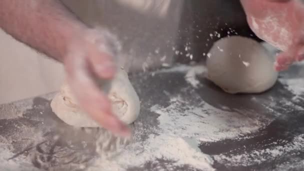 Vue rapprochée des mains de boulanger pétrissant la pâte sur la table. Procédé de fabrication, fabrication du pain. Mouvement lent  . — Video