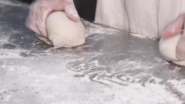 Vista de perto das mãos do padeiro amassando a massa na mesa. Processo de fabricação de pão. Bakery Workplace. 4k . — Vídeo de Stock