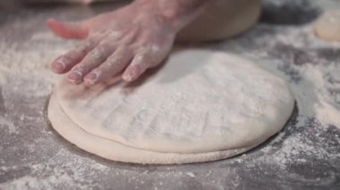 Fırıncı mutfakta elle pizza hamuru germek. Yavaş çekim.