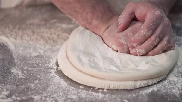 Piekarz przygotowuje okrągły chleb ciasta, obracając i ugniatając ciasto. — Wideo stockowe
