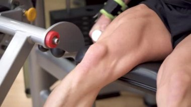 Spor salonu bacak kıvırma eğitmen dışarı çalışan kaslı bacaklar ile adam atlet yakından görünümü. 4k görüntü. 