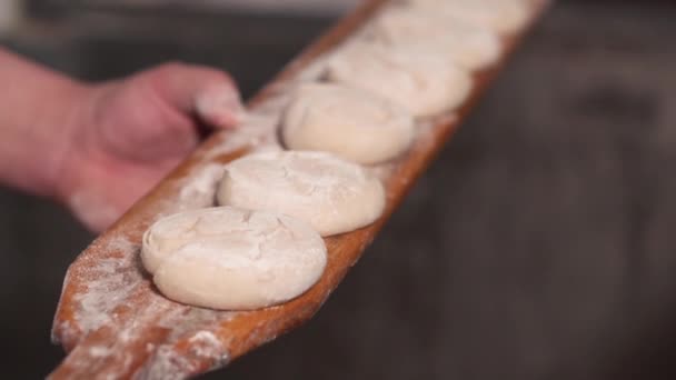 Der Bäcker legt den Teig in den Ofen. Zeitlupe. Nahaufnahme. — Stockvideo
