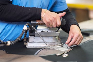 Semstress kumaşı ütülüyor. dikiş atölyesinde terzi demirleri fabirc.