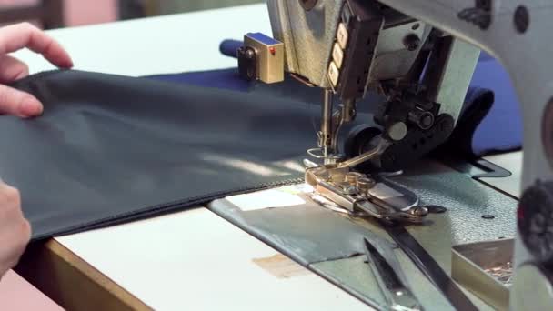 En sömmerska syr trasor i tyg Atelier produktionslinje. Närbild av en symaskin. — Stockvideo