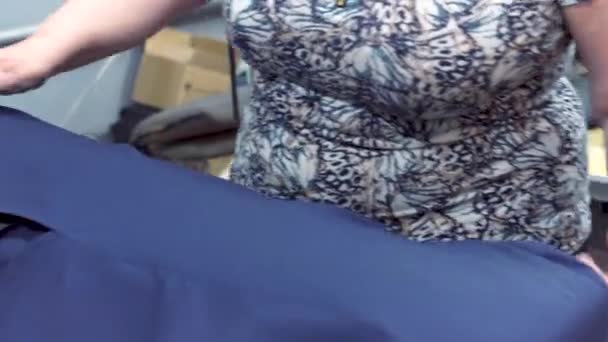 Крупный план: Женщина-швея парит пиджак при помощи старомодного утюга. Женская рука держит утюг и разглаживает пиджак, пар от утюга . — стоковое видео