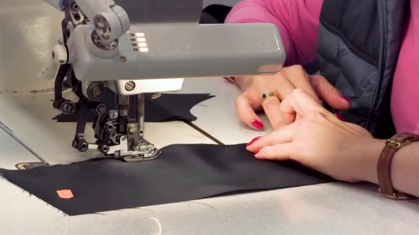 Una sarta cuce tessuti in linea di produzione atelier tessuto. Avvicinamento di una macchina da cucire . — Video Stock