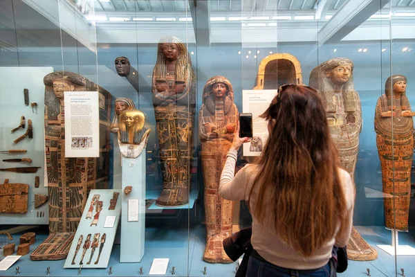 Londres, Reino Unido - 13 de mayo de 2019: The British Museum, Londres. Salón del Antiguo Egipto, turista tomando una foto de la exposición de momias antiguas . — Foto de Stock
