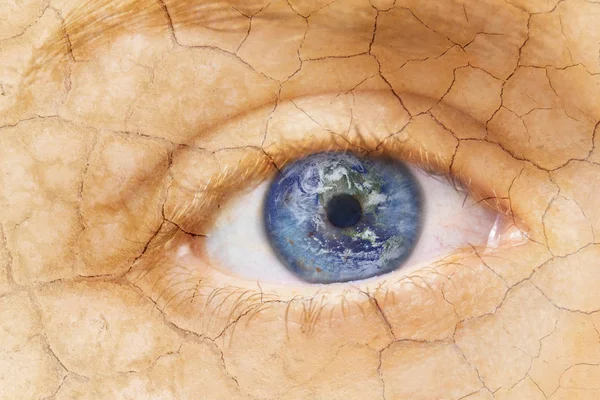 Concetto di riscaldamento globale. Immagine ravvicinata di donna incrinato faccia strutturata con terra di iride. Composito creativo di macro Occhio con Terra come Iris. Elementi di questa immagine forniti dalla NASA . — Foto Stock