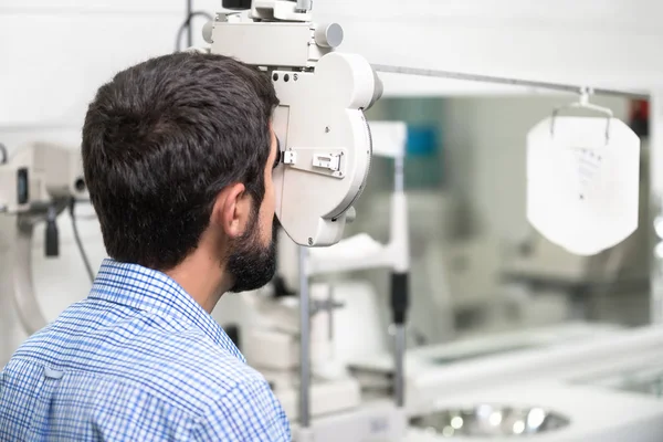 Пациент читает карту оптика в современной офтальмологической клинике . — стоковое фото