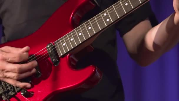 Музикант грає на червоній електрогітарі . — стокове відео